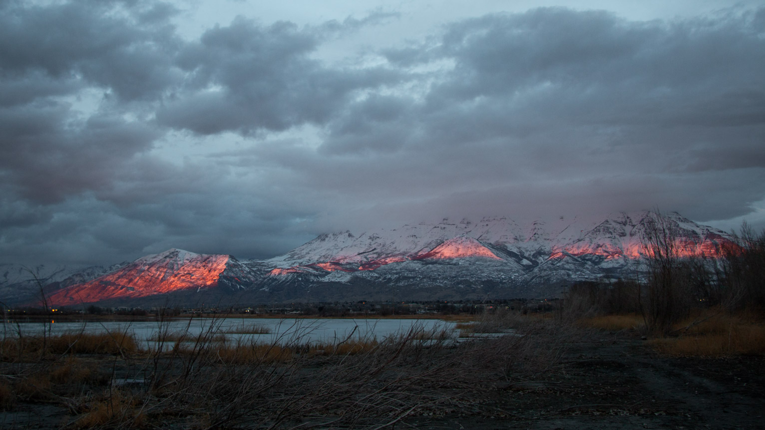 the mountains blue mountains are lit in a sort of red line by the setting sun